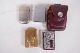 A floral engraved chrome plated Zippo lighter in a leather belt pouch together with a brass cased