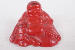 A Chinese cinnabar lacquer style figure of Buddha, 2" wide