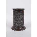An C18/19th Oriental bronze brush pot with three panels decorated with a scrolling floral design,