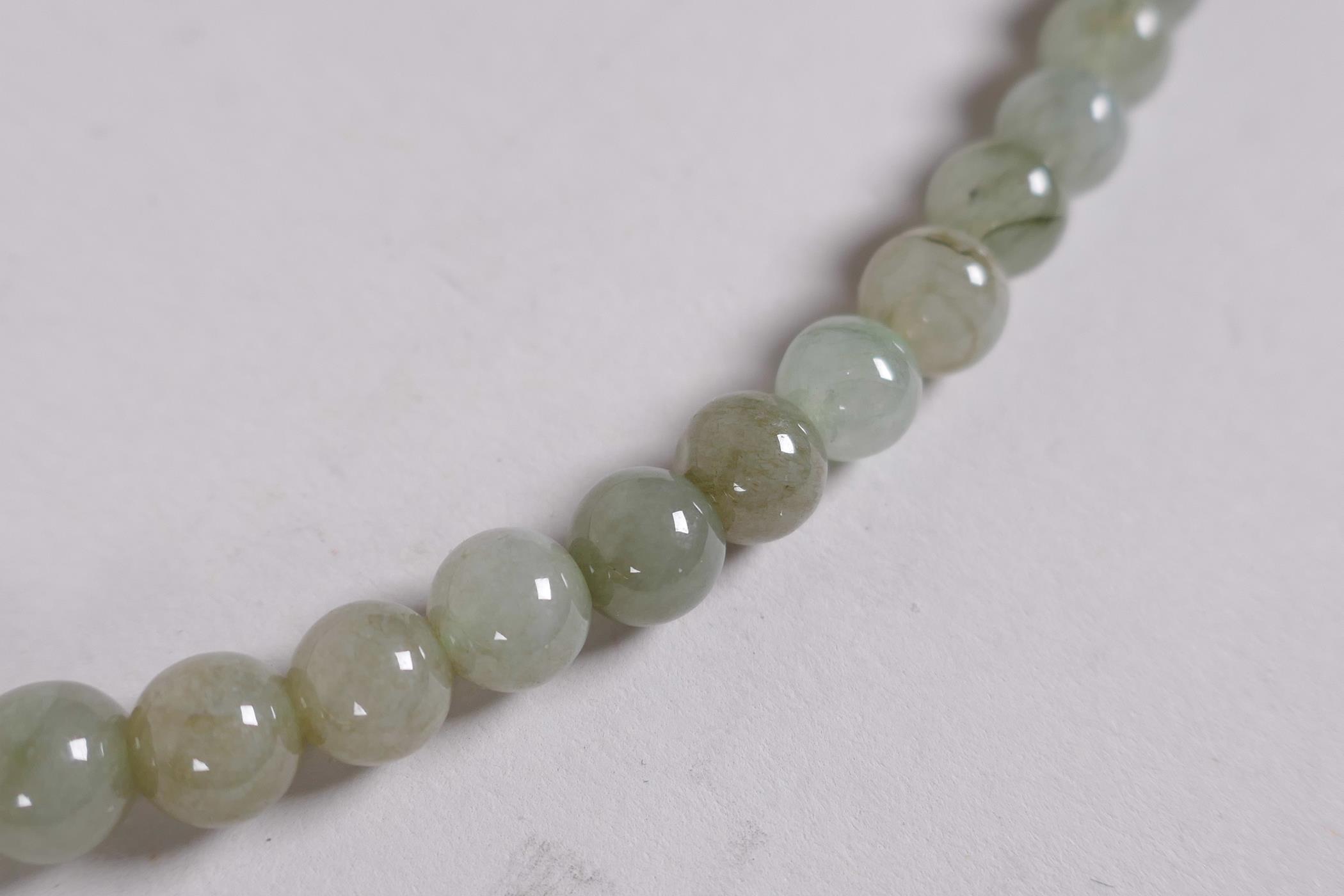 A Chinese celadon jade necklace, 27" long - Image 3 of 4