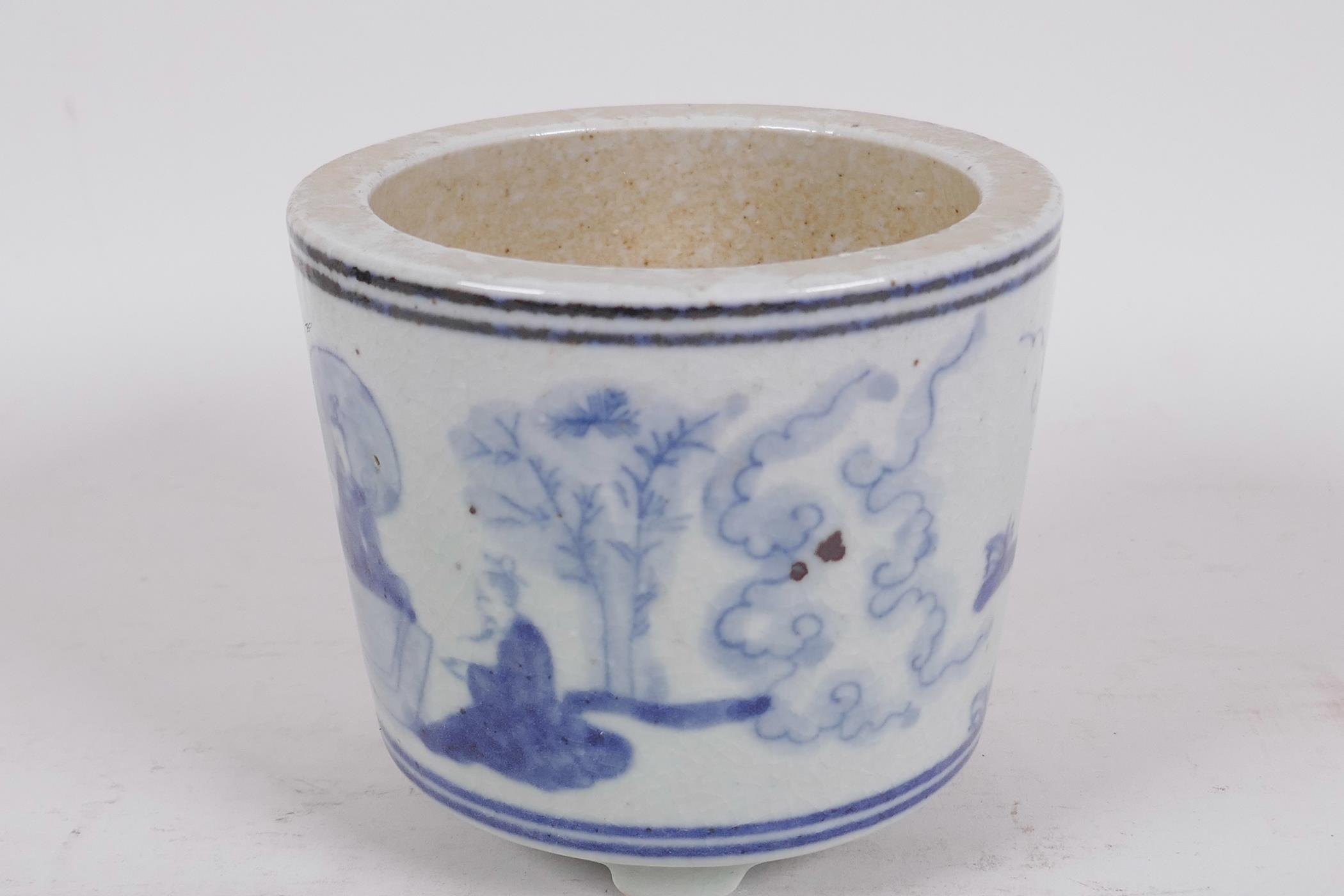 A squat Chinese blue and white porcelain cylindrical base on three feet decorated with figures in