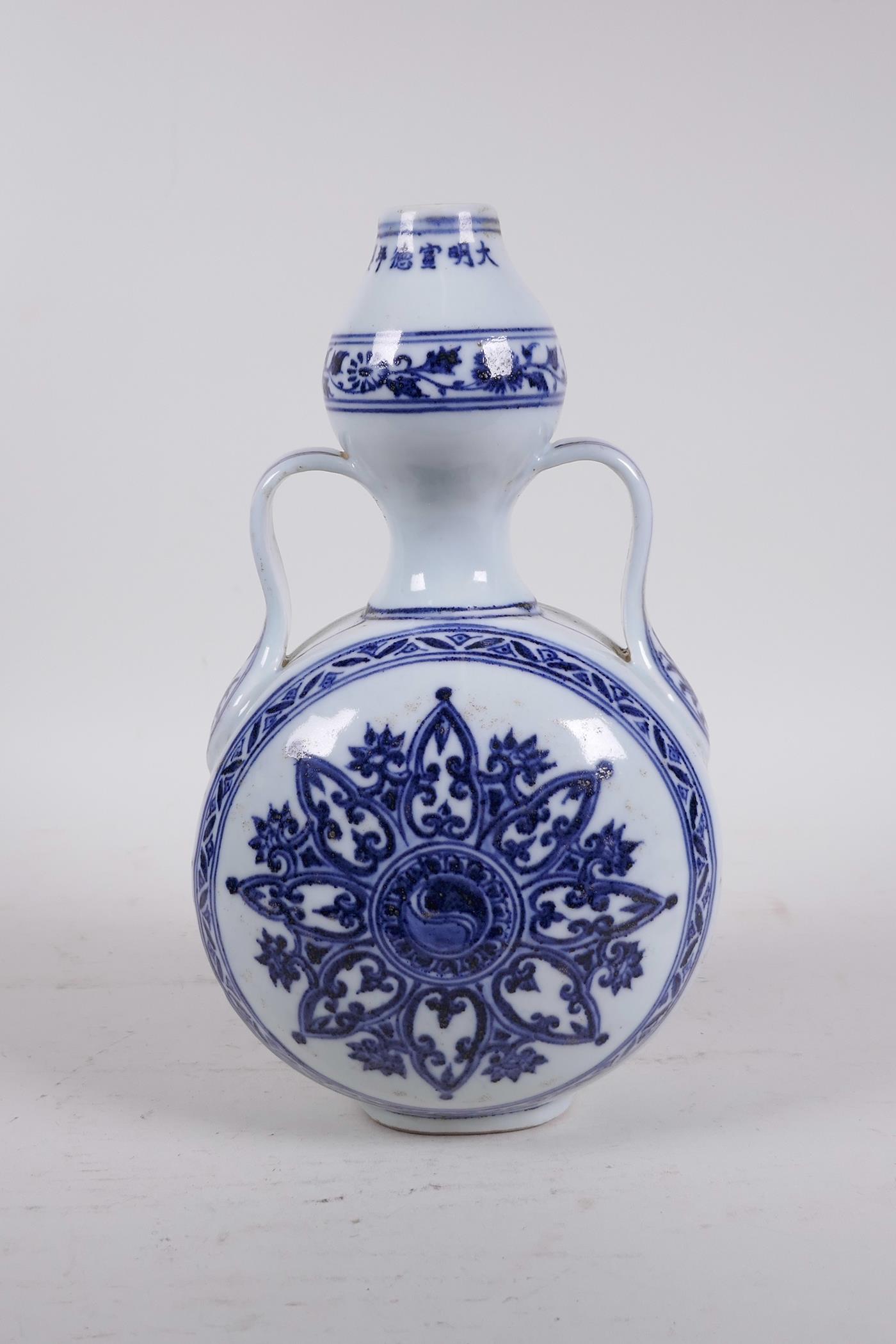 A Chinese blue and white porcelain garlic head shaped flask with two handles and Yin Yang