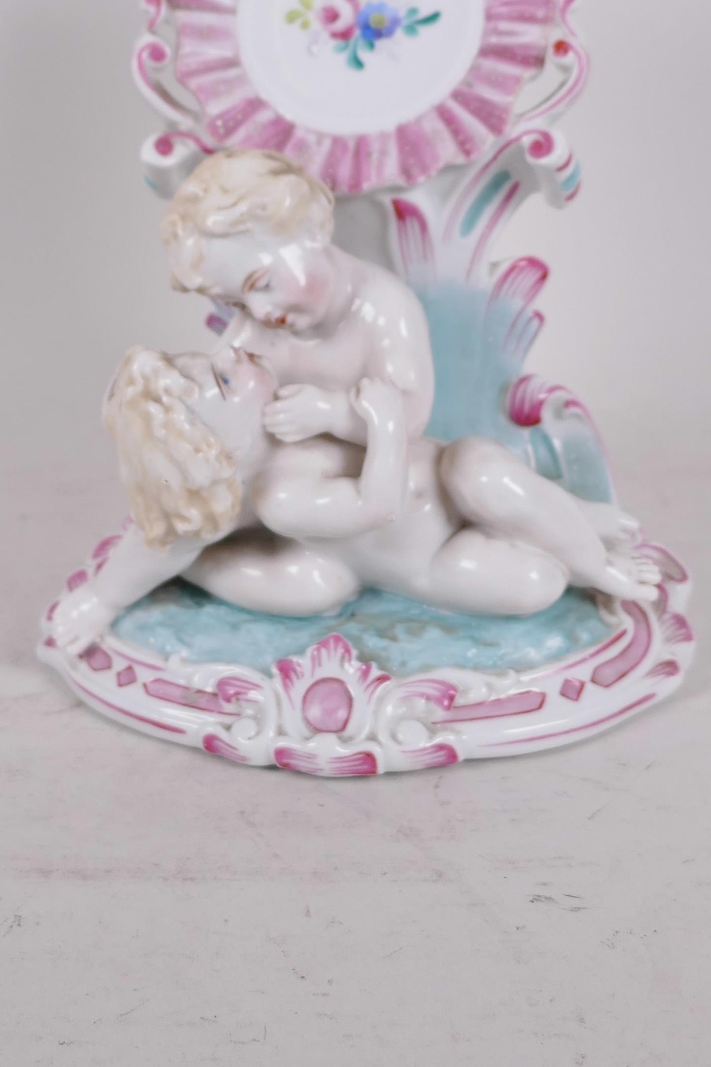 A C19th Continental porcelain watch holder formed as two children in a garden hand painted with - Image 3 of 3