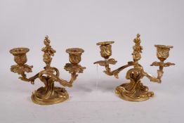 A pair of gilt brass two branch rococo style dwarf candlesticks, 6" high