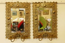 A pair of C19th pressed brass framed pier glass wall mirrors with twin candle sconces, the frames