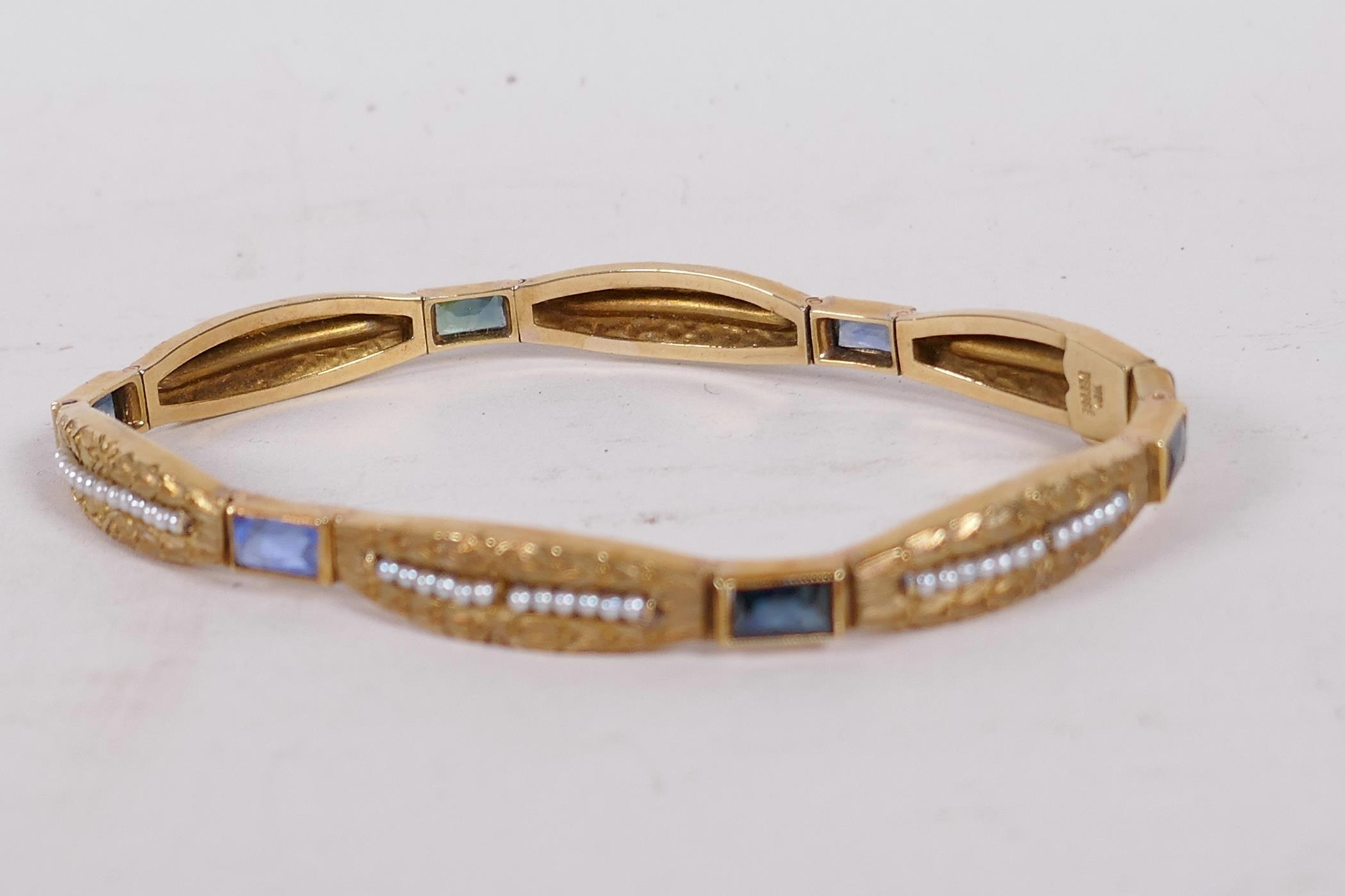 An 18ct gold bangle set with sapphires and seed pearls, and having bark finish engraving (15 grams - Image 2 of 6