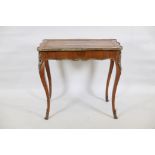 A C19th French rosewood writing table, with brass mounts, the shaped top inset with blind tooled