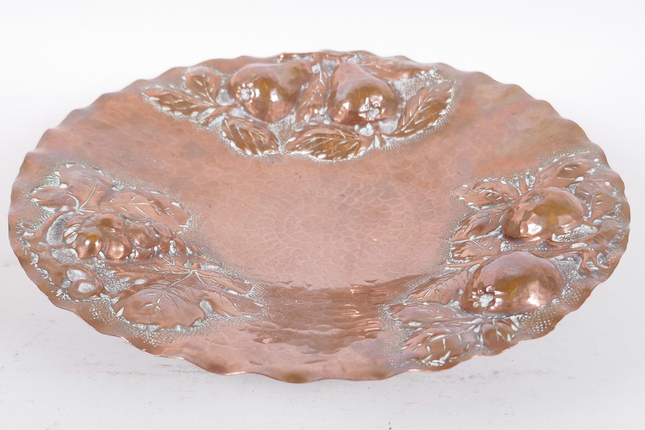 A beaten copper pedestal fruit dish with embossed apple, pear and grape decoration, 10¾" diameter - Image 3 of 4