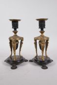 A pair of Regency bronze and ormolu candlesticks with palmette decoration and suspended acorn