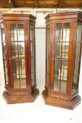 A pair of hardwood canted front display cabinets, raised on plinth bases, 38" x 16" x 76"