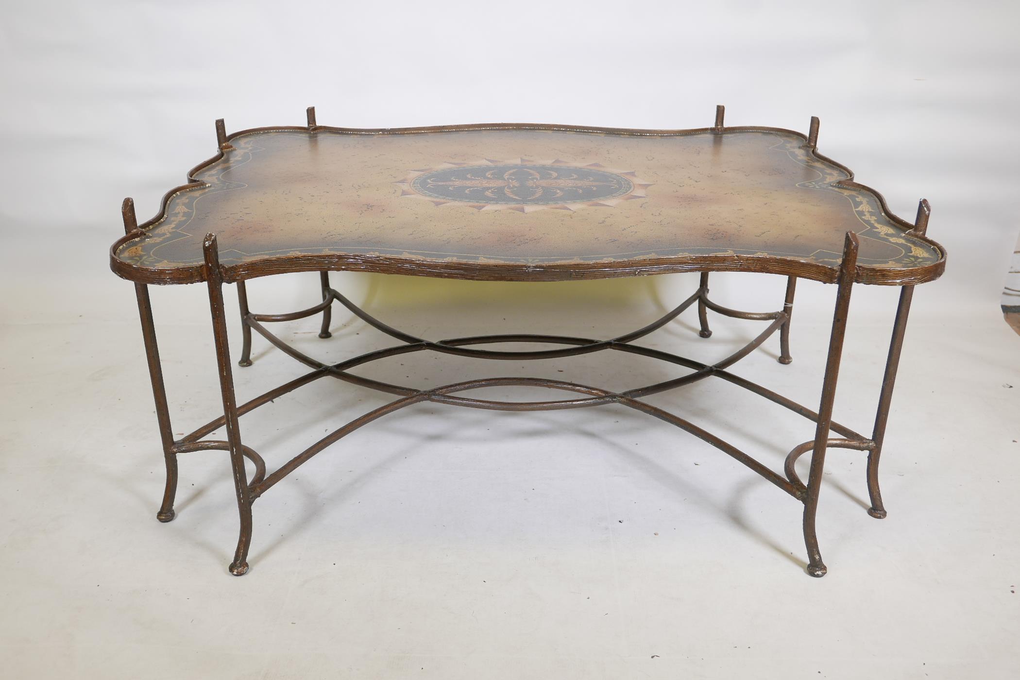 A painted metal framed low table, with hand painted shaped top, raised on sabre supports with