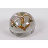 A heavy glass paperweight decorated with lilies, 3½" diameter