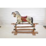 An early C20th carved and painted wood rocking horse with an upholstered saddle, 47" long