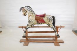 An early C20th carved and painted wood rocking horse with an upholstered saddle, 47" long