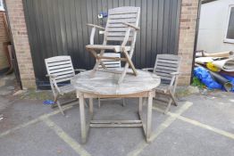 A teak extending garden table and four folding chairs, 71" x 47", 29½" high extended