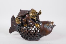 A Chinese bronze incense burner in the form of a fisherman riding a carp, with gilt highlights, 4