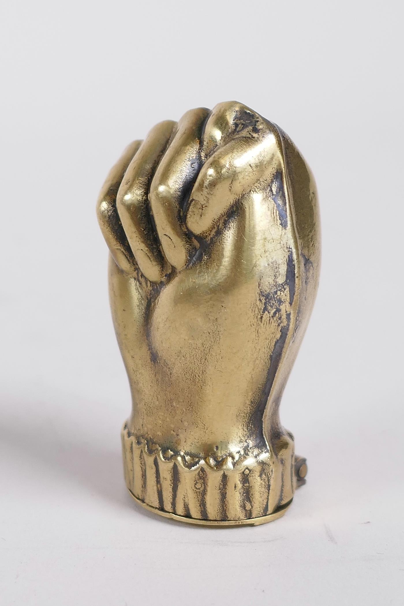 A brass vesta case in the form of a clenched fist, 1½"