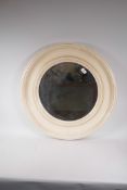 A circular bevelled glass wall mirror in a dished moulded frame, 26½" diameter