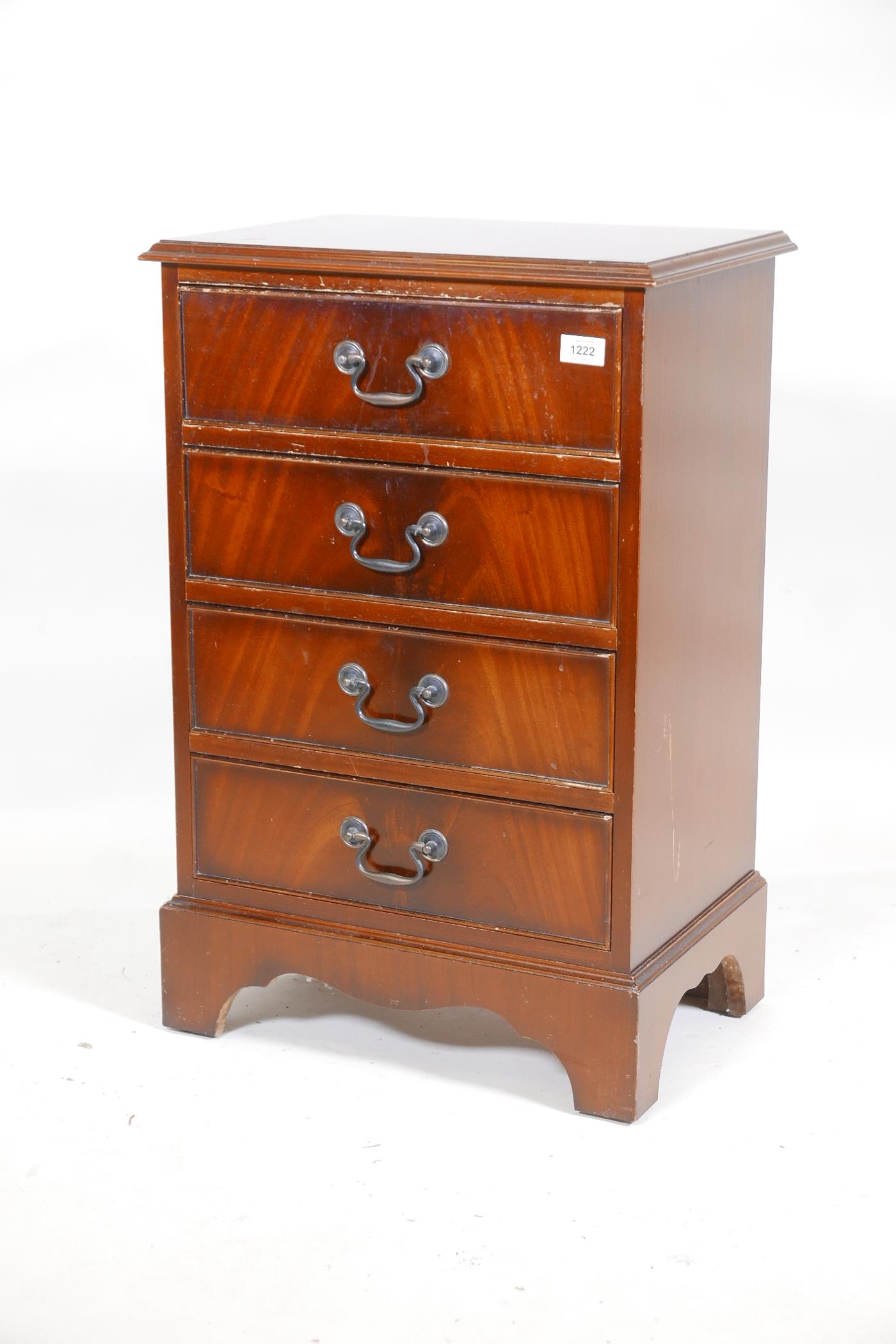 A mahogany veneered chest of four long drawers, with brass handles, raised on bracket supports,