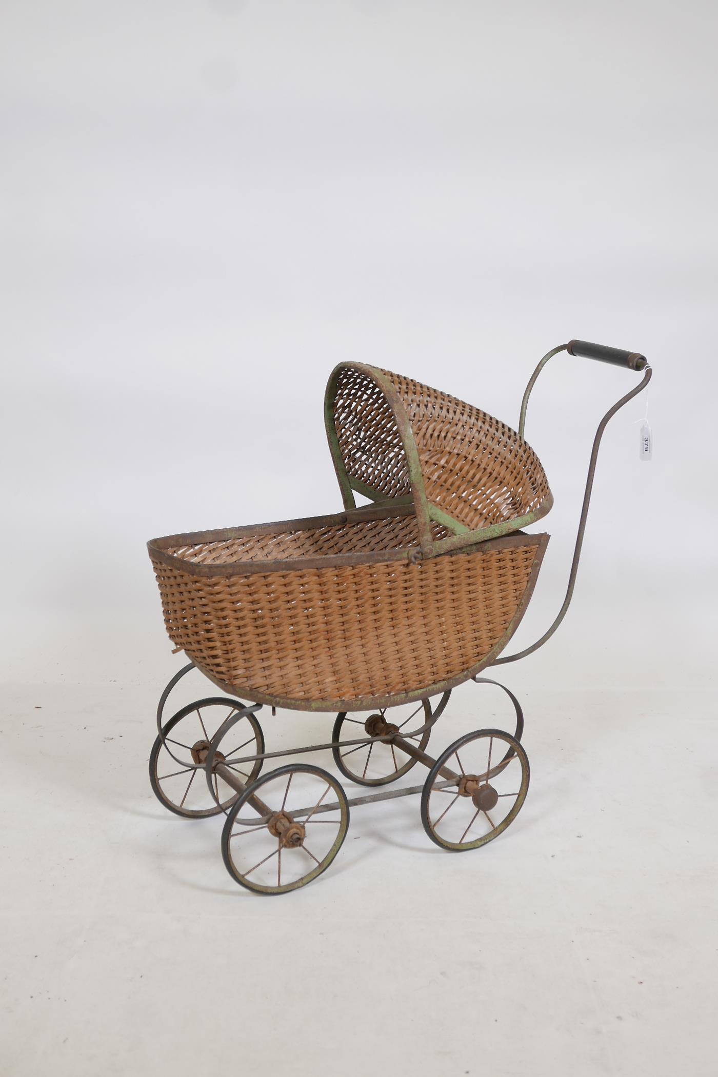 A metal framed and cane doll's pram, early C20th, 22" x 8" x 24"