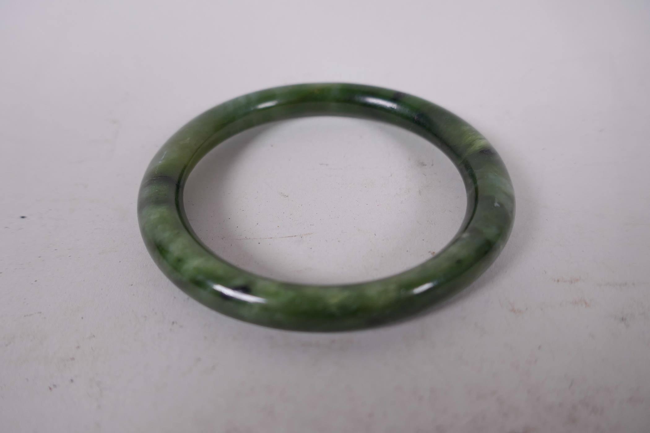 A Chinese marbled green jade bangle, 2¼" diameter, 43 grams