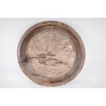 An antique turned and carved rustic wood platter, 24½" diameter