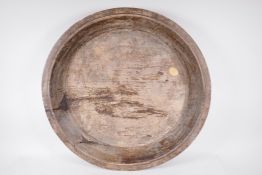 An antique turned and carved rustic wood platter, 24½" diameter