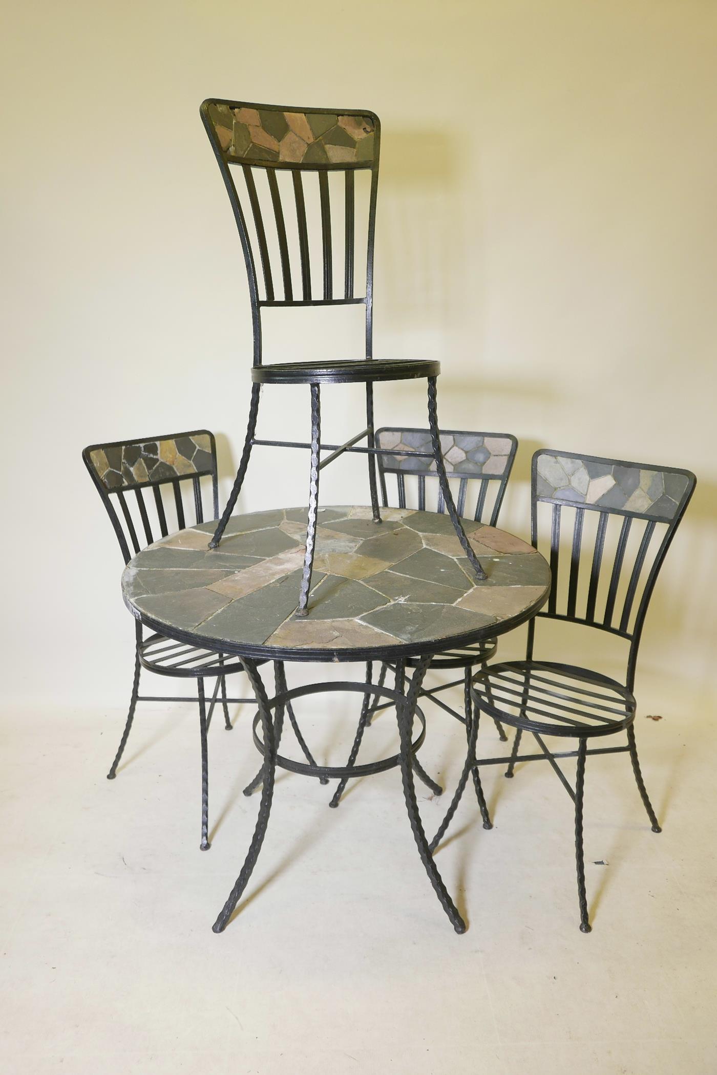 A circular wrought iron and slate garden table on twisted supports, 30" high, 36" diameter, together