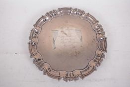 A hallmarked silver card tray with shaped rim on three scrolled feet, hallmarked London 1967 with