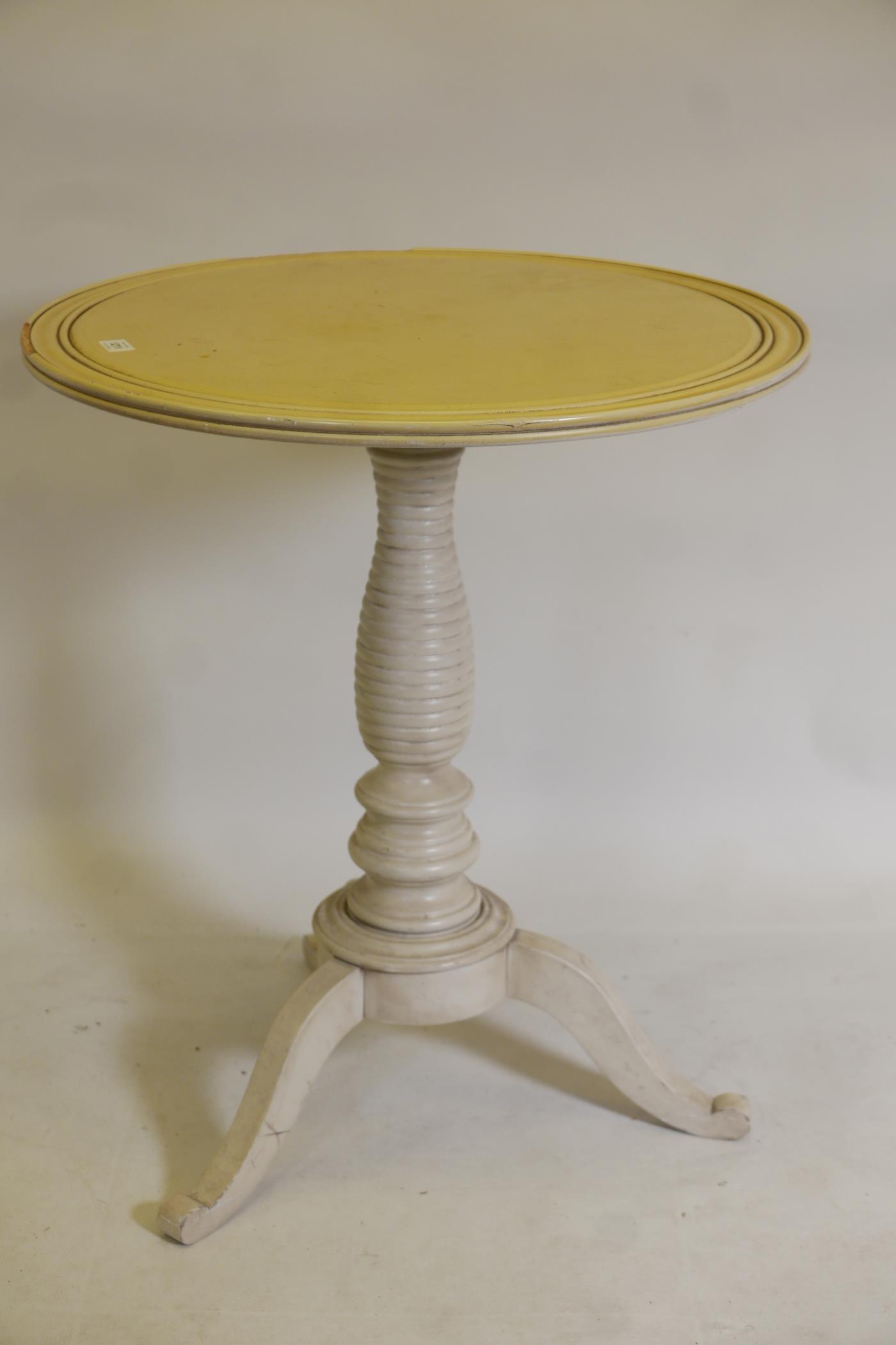 A painted centre table, raised on a ring turned 'beehive' column and tripod supports, 25" x 29"
