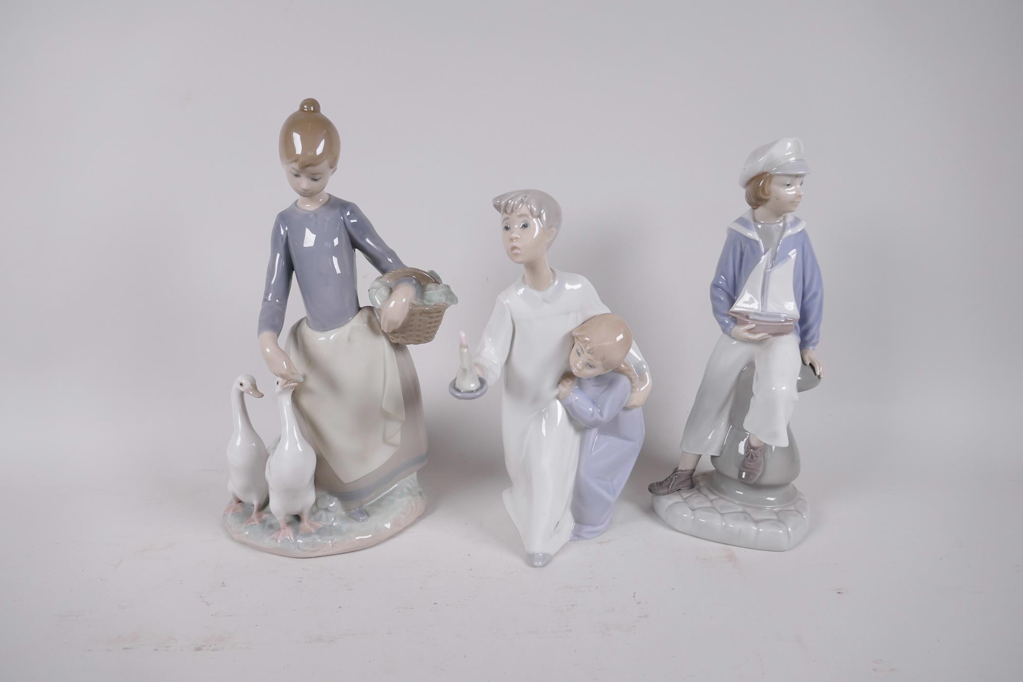 Three Lladro figurines, 'Girl with Geese', 'Sailor Boy' and 'Two Children at Bedtime', tallest 10"