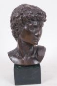 A bronze bust of David after the classical, mounted on a square base, 6¾" high