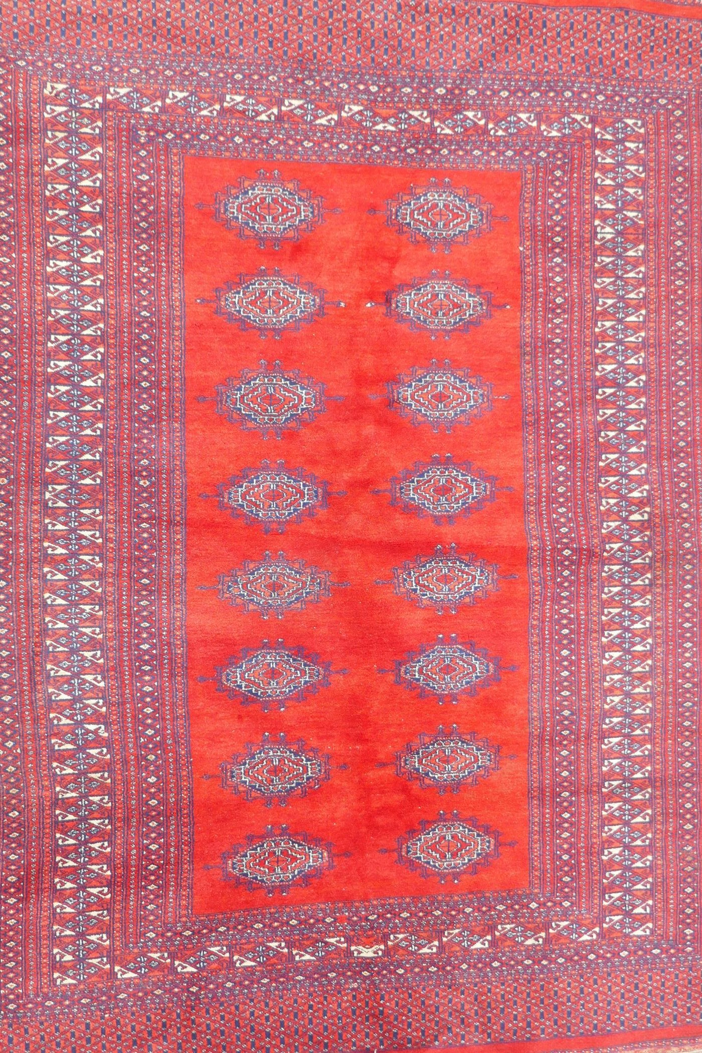 A Turkmen tomato ground wool carpet with a Bokhara design, 51" x 72"