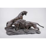 After Thomas F. Cartier, a French bronzed spelter figure of male and female lions, both roaring