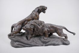 After Thomas F. Cartier, a French bronzed spelter figure of male and female lions, both roaring