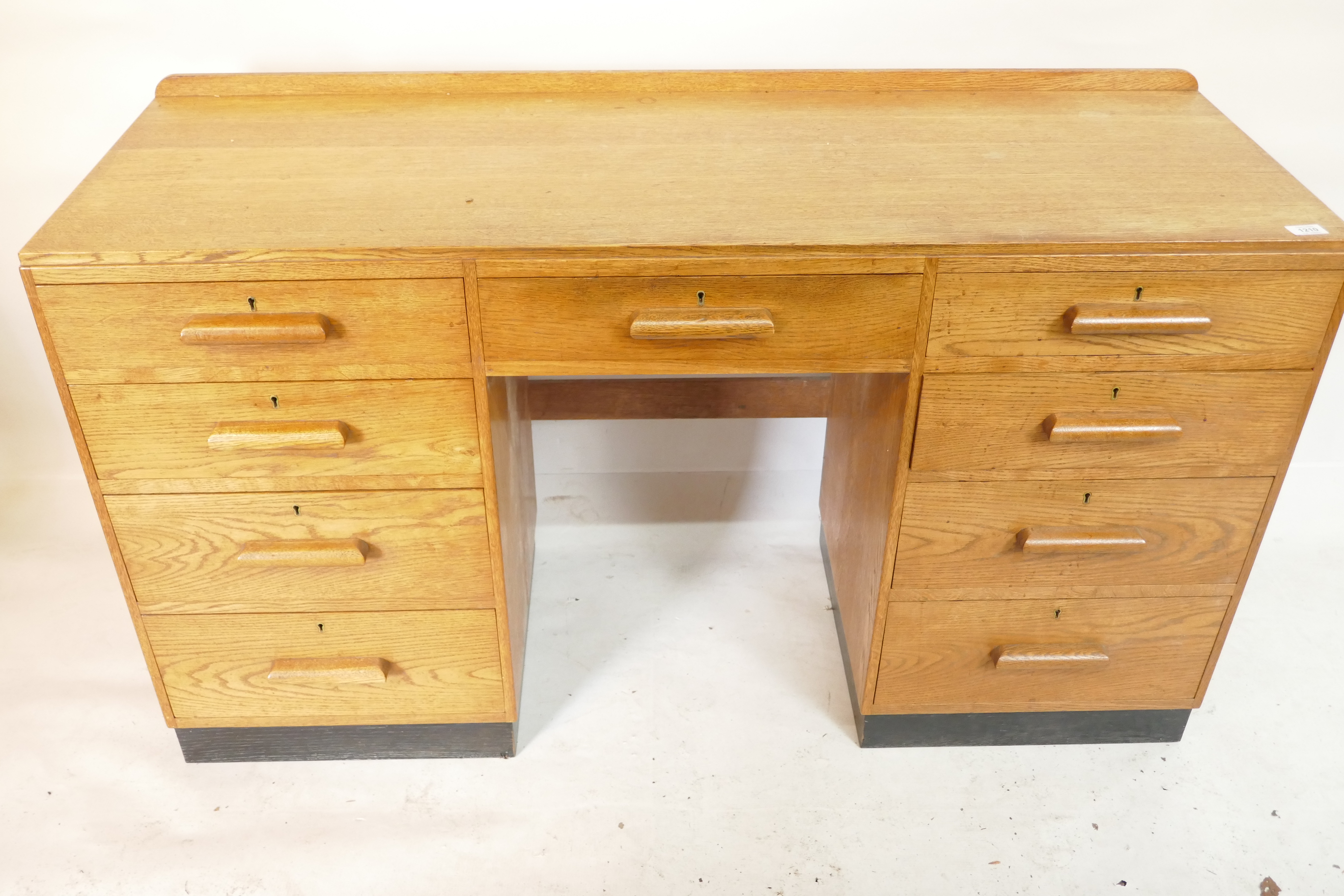 An Art Deco oak nine drawer kneehole desk, raised on a painted plinth, 54" x 18" x 30" - Image 2 of 2