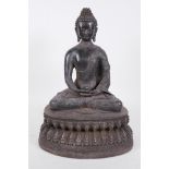 A Chinese bronze figure of Buddha seated in meditation on a lotus throne, holding a small censer,