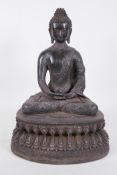 A Chinese bronze figure of Buddha seated in meditation on a lotus throne, holding a small censer,