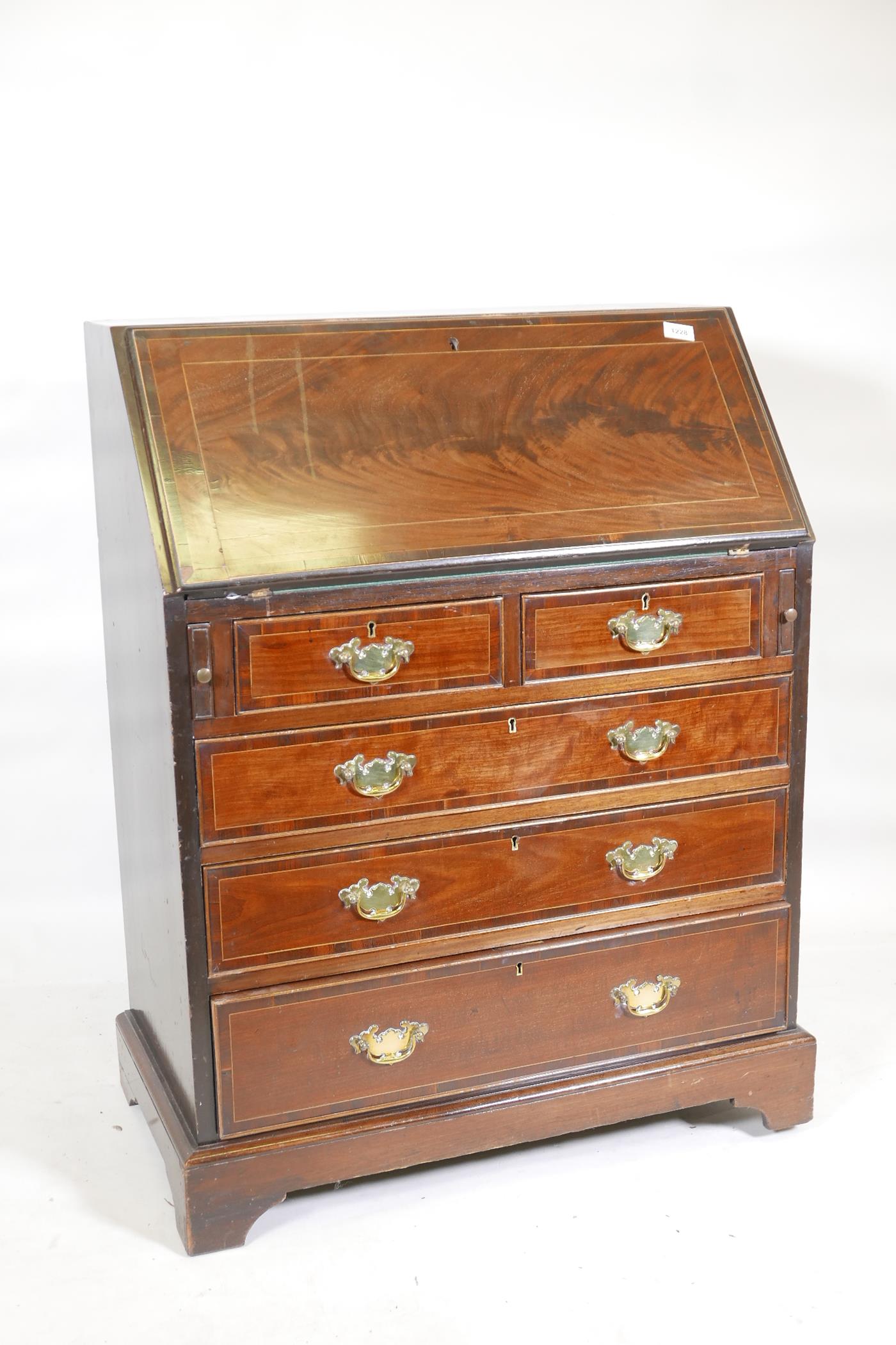 A figured mahogany fall front bureau, with boxwood stringing fitted interior and brass plate