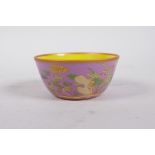 A Chinese polychrome porcelain tea bowl with enamel floral decoration on a rose ground, 6