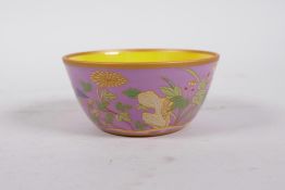 A Chinese polychrome porcelain tea bowl with enamel floral decoration on a rose ground, 6