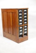 An oak filing cabinet with sixteen metal drawers, lacks two drawers, 12" x 27" x 30"