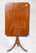 A C19th mahogany tilt top occasional table, with canted corner top, raised on turned column and