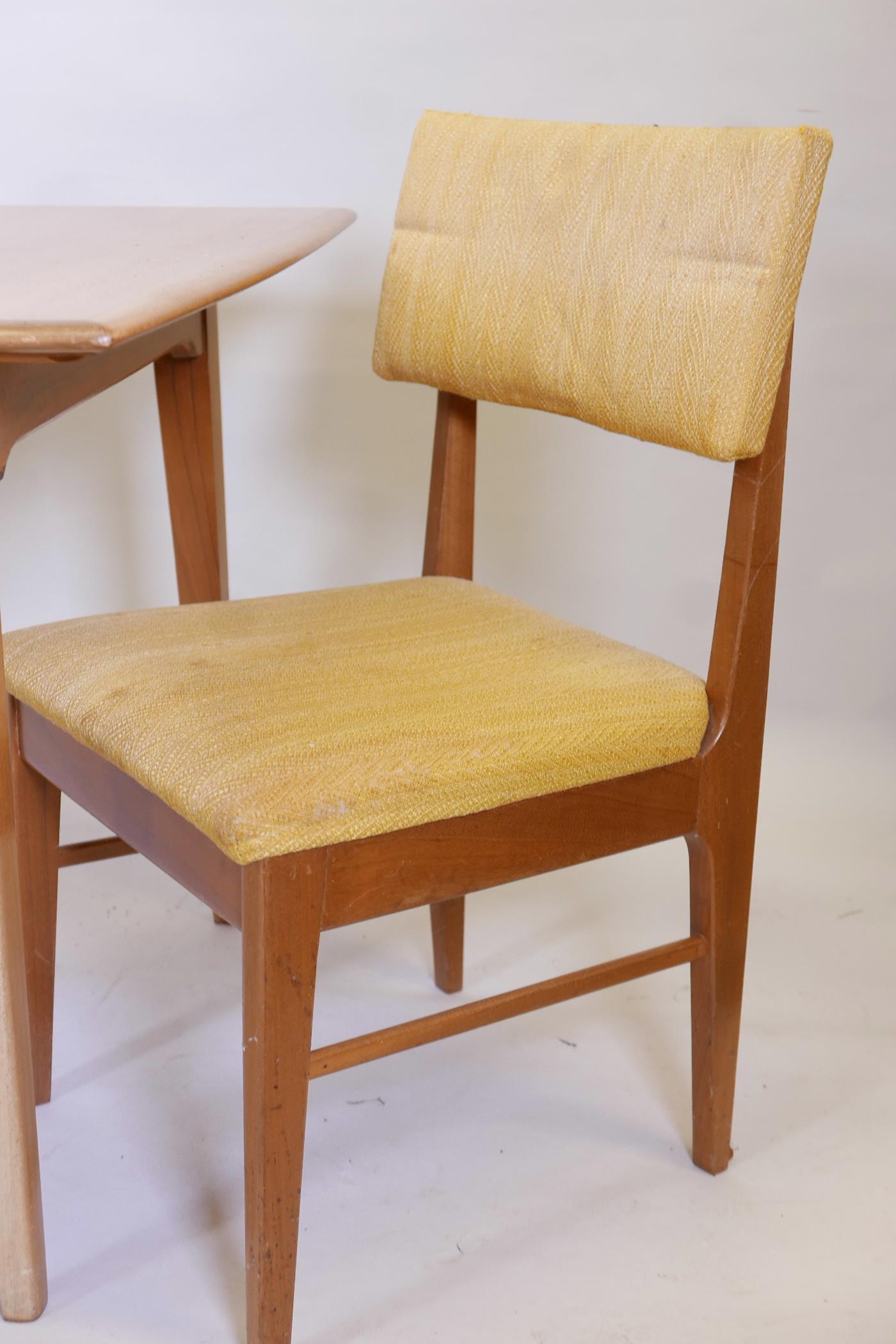 A 1970s teak extending dining table on square tapering supports, with built in leaf, and two - Image 2 of 3