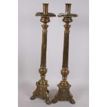 A pair of brass pricket style candlesticks, fitted with candle holders, the fluted columns on
