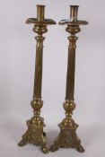 A pair of brass pricket style candlesticks, fitted with candle holders, the fluted columns on