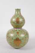 A Chinese double gourd porcelain vase, with green enamel and gilt lotus flower decoration,