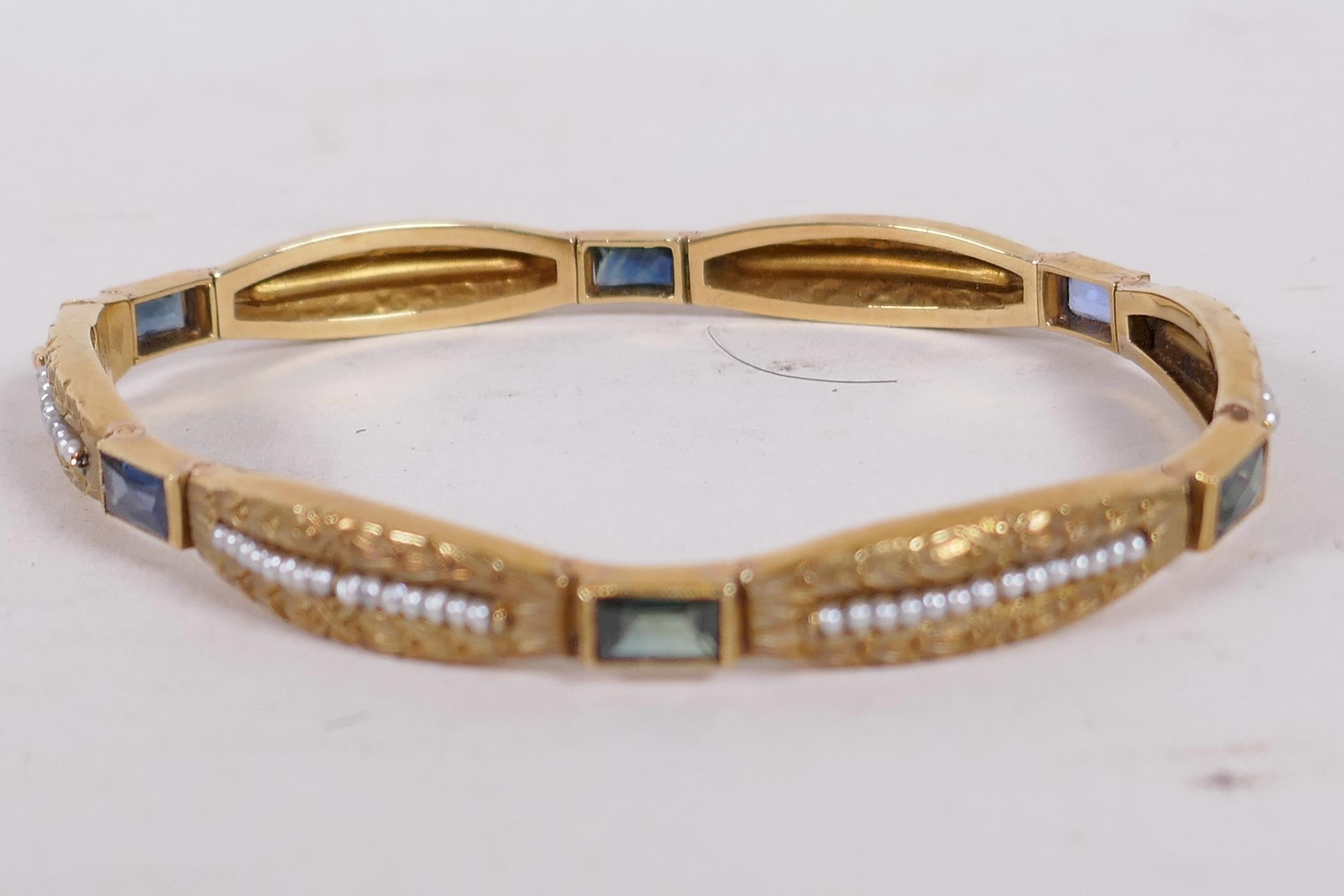 An 18ct gold bangle set with sapphires and seed pearls, and having bark finish engraving (15 grams - Image 3 of 6