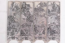 Four Chinese white metal scroll weights in the form of screen panels cast with landscape scenes, two