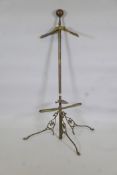 An early C20th brass valet stand raised on tripod supports, 56" high